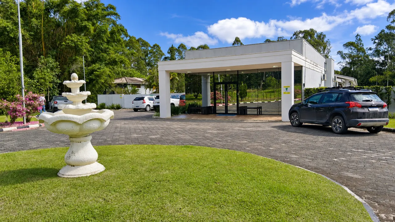 Entrada da Nova Belluno com jardim e fonte na área externa